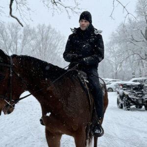 Ryan Kaufmann riding a horse in the snow at the Ashlawn Estate